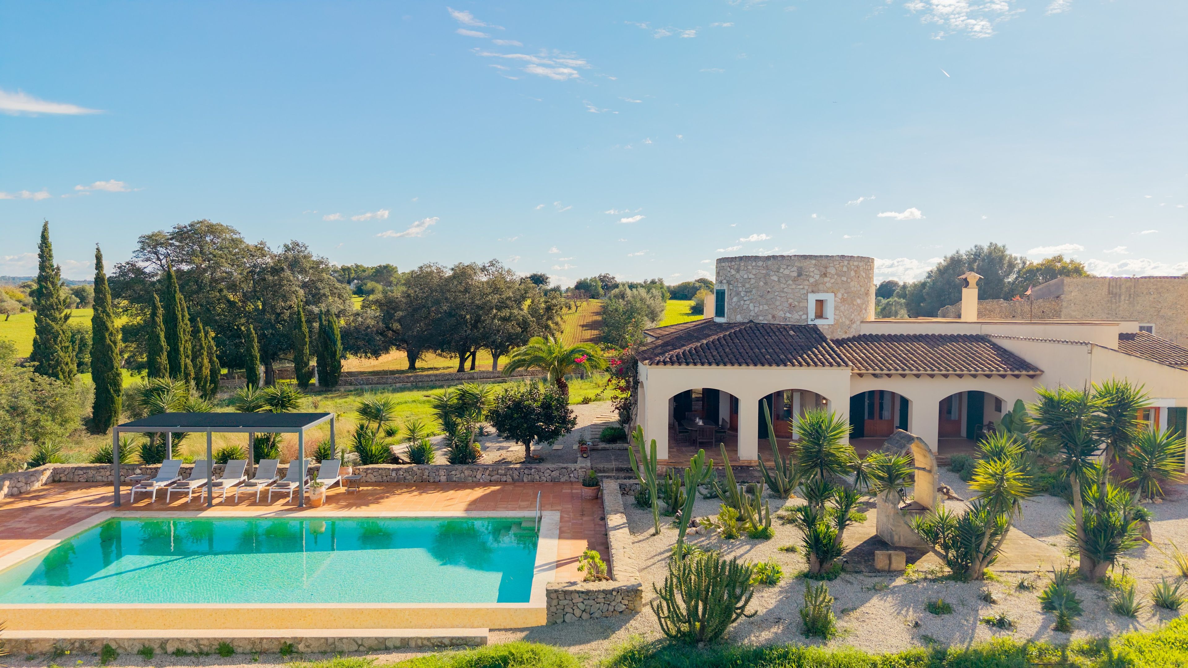 Una villa con piscina, zona de estar exterior y vistas al campo.