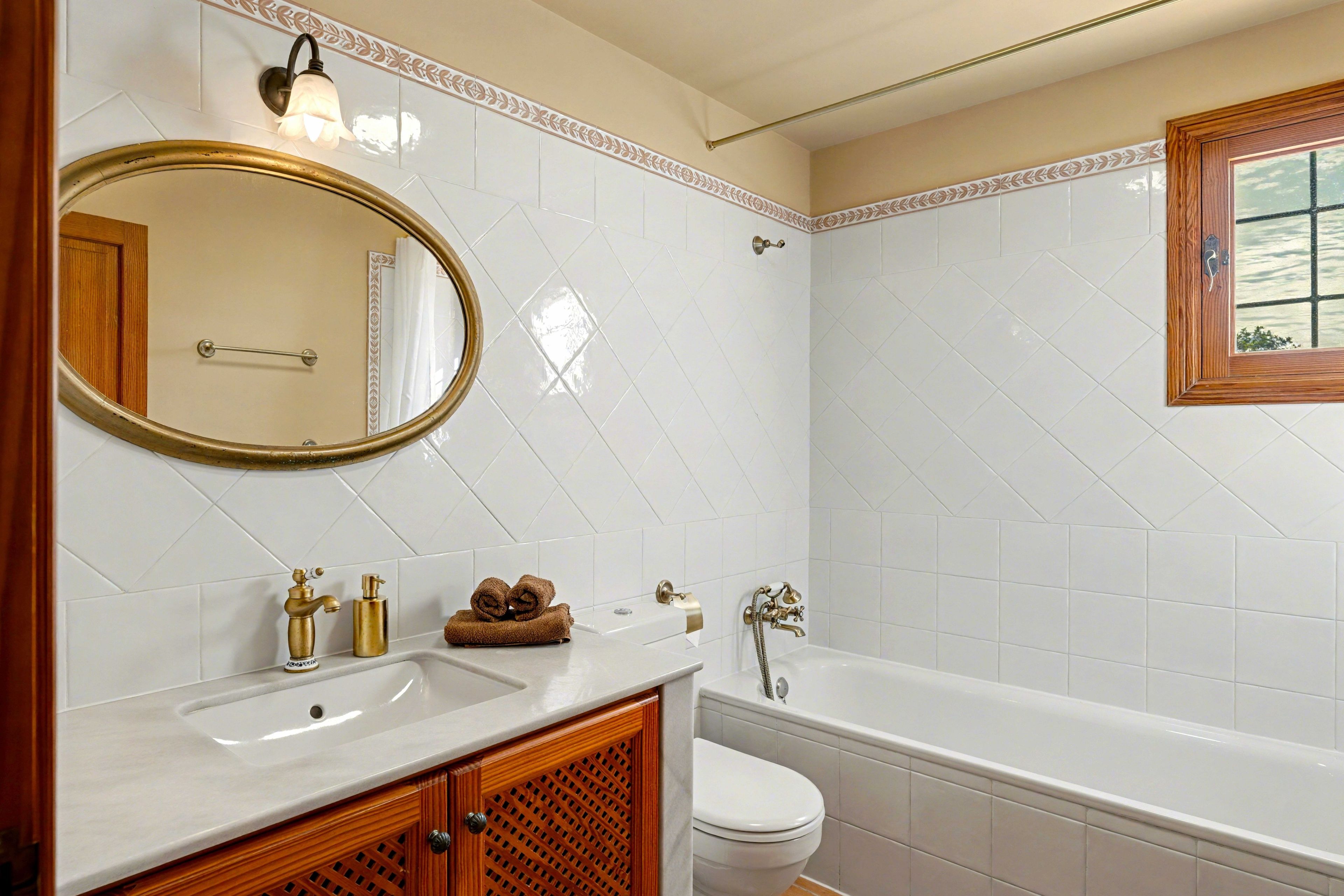 A bathroom with a white sink, a mirror, a toilet, and a bathtub.