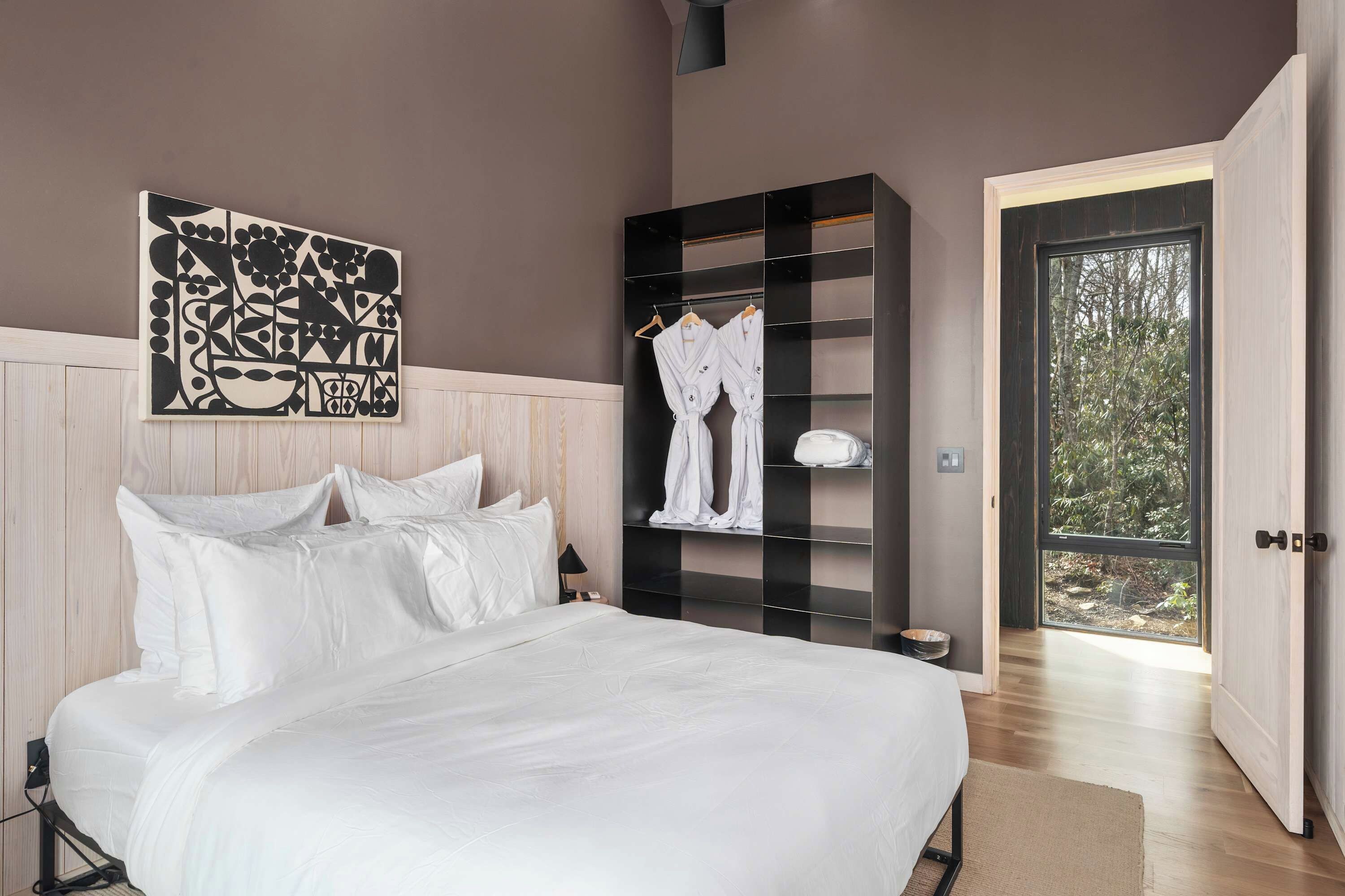 A bedroom with a bed, a wardrobe, and a door leading outside.