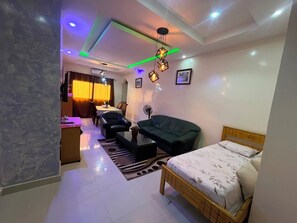 A modern bedroom with a bed, a sofa, a coffee table, and a desk. - Villa Soleil du Sénégal : Nimes (Dakar)