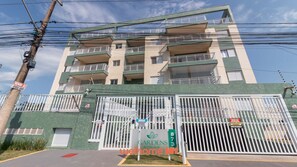 Un edificio residenziale a più piani con balconi, un ingresso con cancello e un cartello che indica che l'immobile è in vendita.