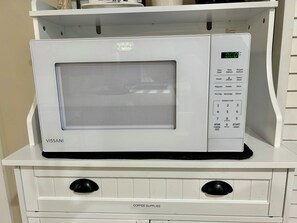 A white VISSANI microwave oven with a digital display, control panel, and a 'COFFEE SUPPLIES' label on the drawer below.