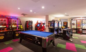 A pool table in the center with arcade games around it. - Ocea Coastal Luxe at Chevron (Surfers Paradise)