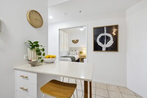 A modern bathroom with a white sink, a mirror, and a towel rack. - Ocea Coastal Luxe at Chevron (Surfers Paradise)