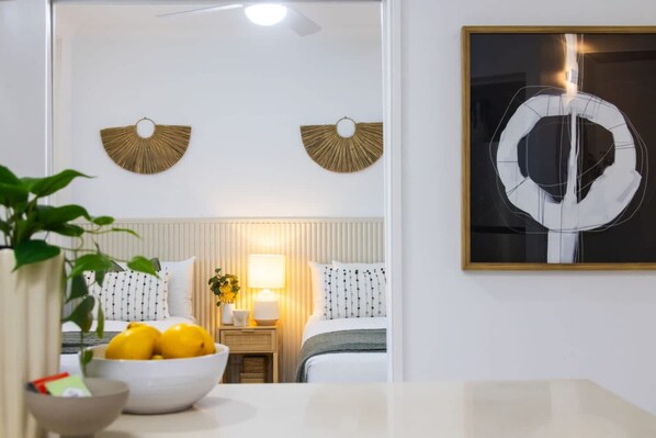 Ein Hotelzimmer mit Bett, Nachttisch, Lampe und einem Bild an der Wand.