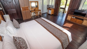 Quarto espaçoso com uma cama grande, escrivaninha, televisão e vista para o exterior.