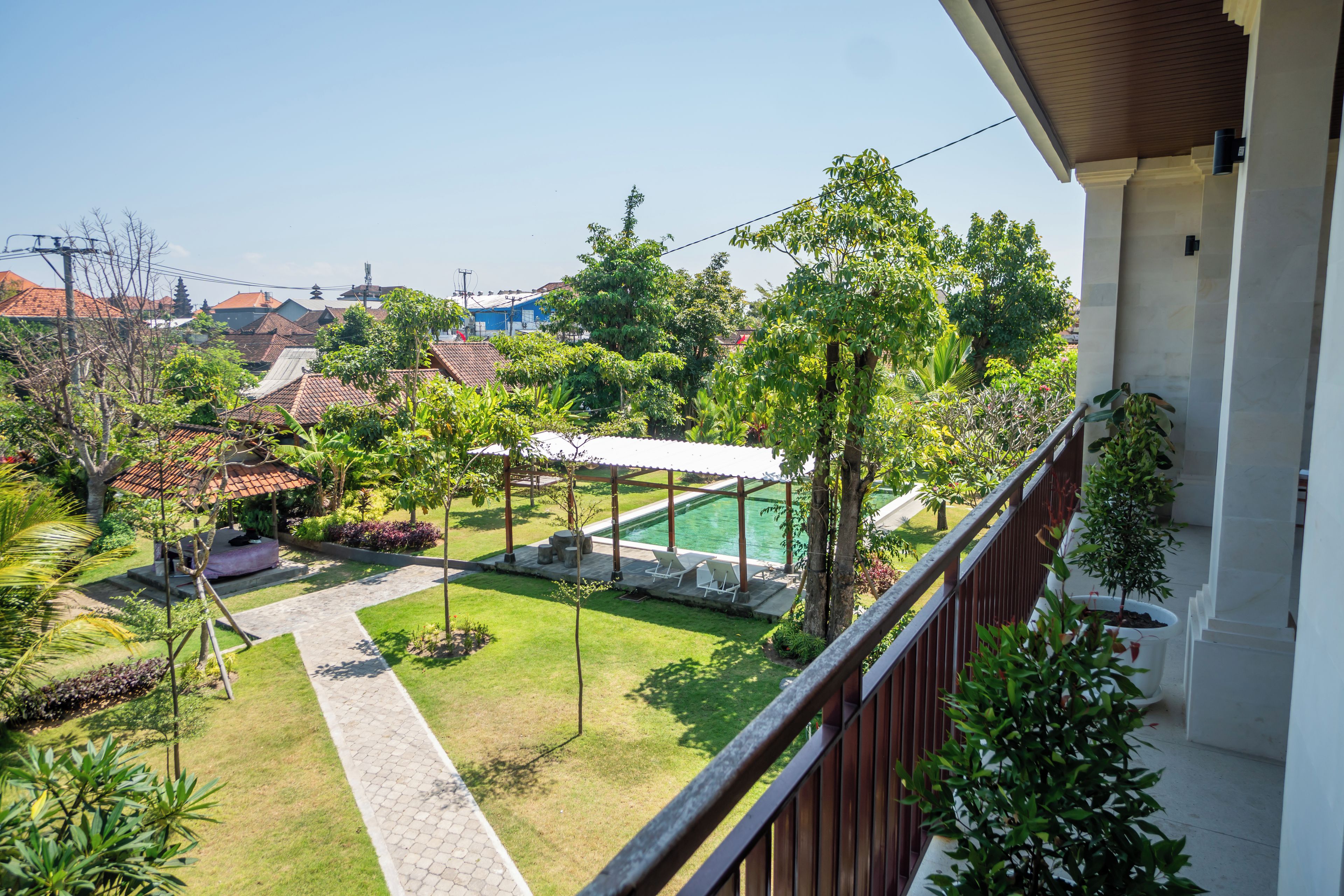 A residential area with a swimming pool, garden, and a view of neighboring houses.