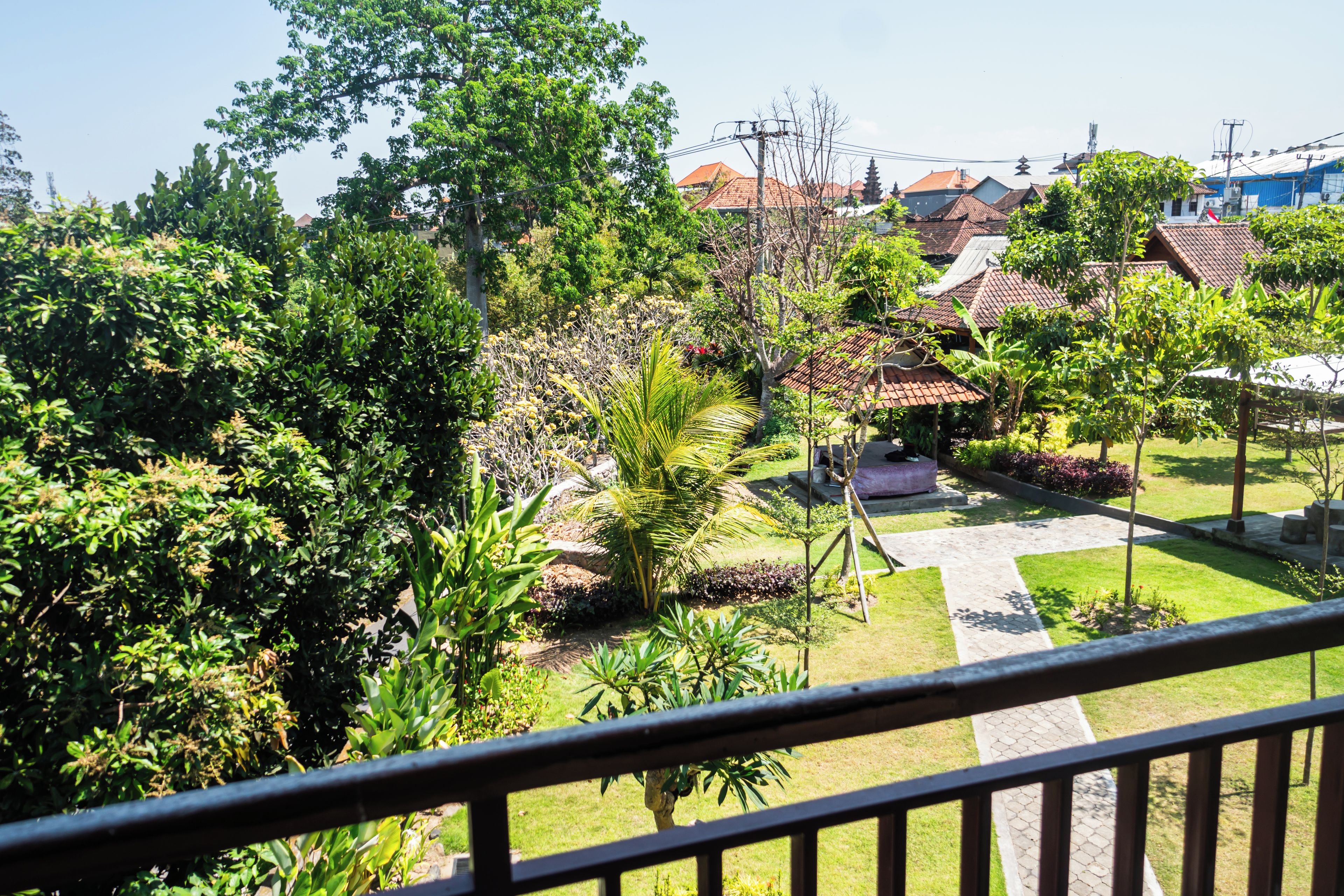 A courtyard with a pathway leading to a building with a tiled roof.
