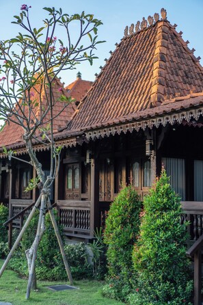 Una casa tradicional de madera con techo de tejas, un porche de madera y un jardín bien cuidado.