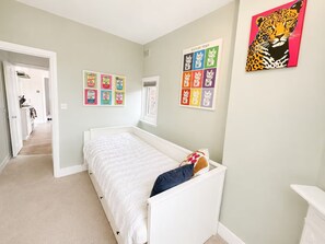 A bedroom with a bed, a door leading to another room, and wall art. - Modern South West London Flat Near Richmond Park - Pass the Keys (London)
