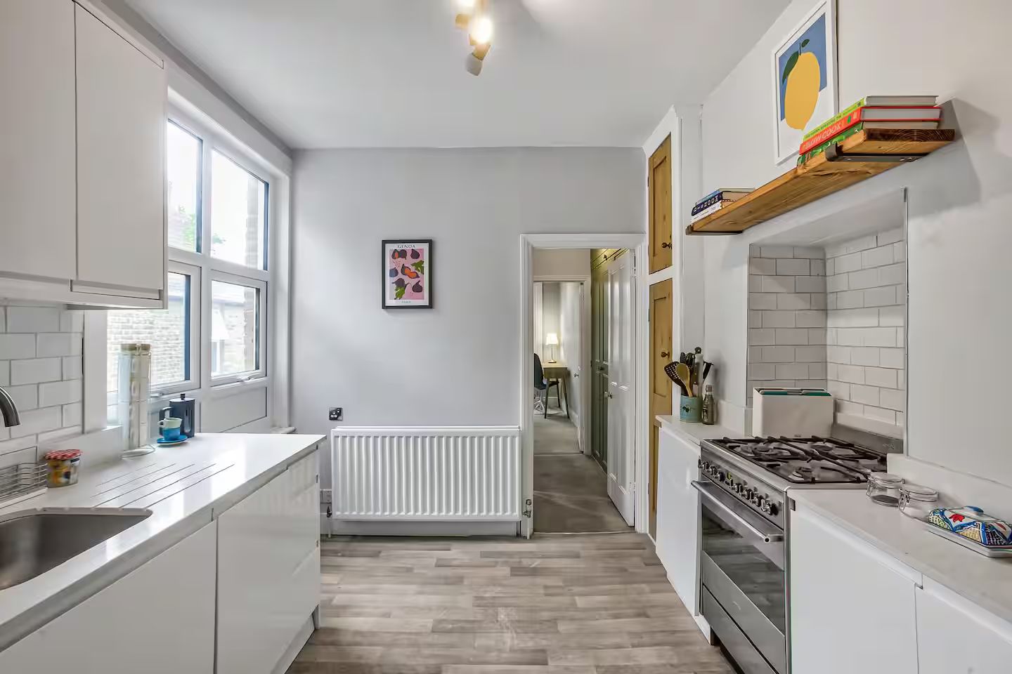 Una cocina moderna con armarios blancos, estufa integrada y ventana que proporciona luz natural.