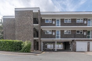 A multi-story building with a brick facade, a covered entrance, and a parking area. - Modern City Centre Apartment | Sleeps 4 | Parking - Pass the Keys (Chelmsford)