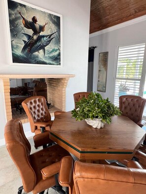 A conference room with a wooden table, leather chairs, a potted plant, and a painting of a figure with a fish. - SlipAway TreasureCay (Treasure Cay)