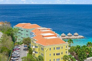 A coastal hotel with multiple buildings, a parking lot, and a view of the sea. - NEW: Blue Bay Beachfront Penthouse 3BDR (Sint Michiel)