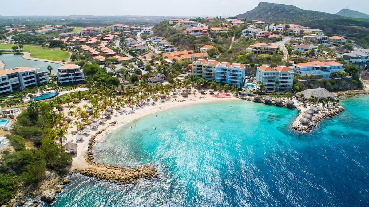 A coastal resort with beachfront villas, a pool, and a beach area.