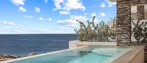 A clear blue sky, a swimming pool, and a view of the ocean.