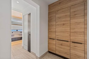 A modern bathroom with a wooden vanity, a shower area, and a white door. - NEW: The Ridge, Penthouse on The Blue Bay Resort (Sint Michiel)