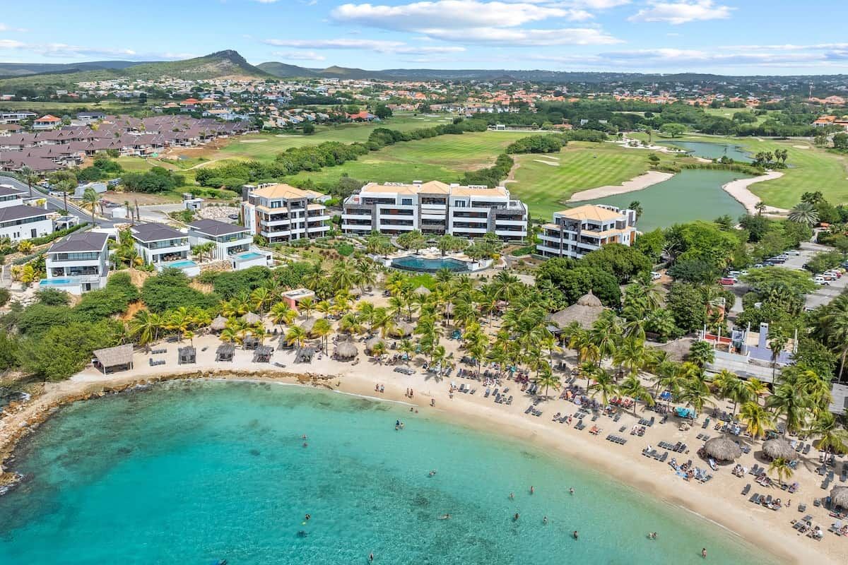 A coastal resort with a beachfront, pool, and golf course.