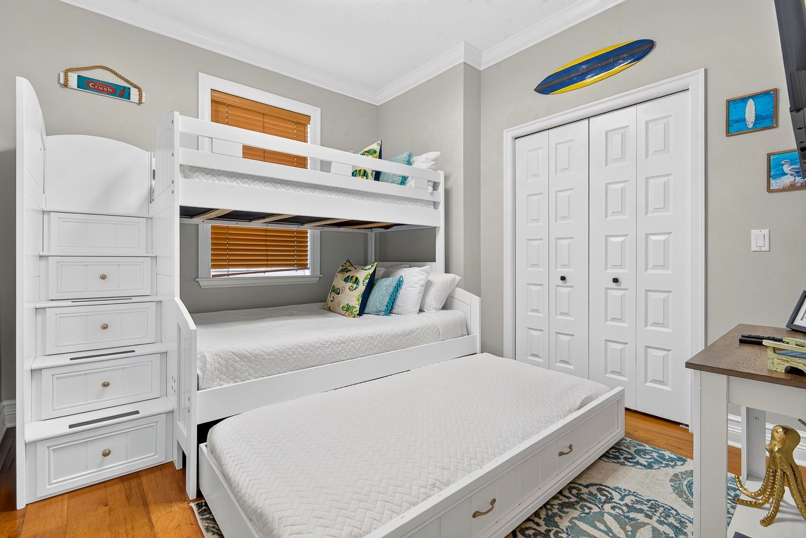 A bedroom with a bunk bed, a desk, and a wardrobe.