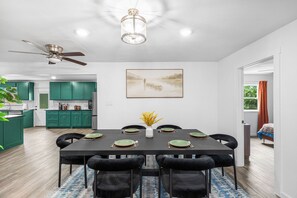 A modern dining area with a black table, green plates, and black chairs. - The Big Country Cactus – Spacious 4BR Home Near Dyess AFB, Job Sites & Colleges (Abilene)