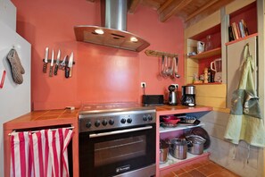 A kitchen with a stove, oven, and various utensils. - BiâO Gîte en Cotentin Holiday Home with Private Terrace, Garden, and Wi-Fi (Bretteville-sur-Ay)