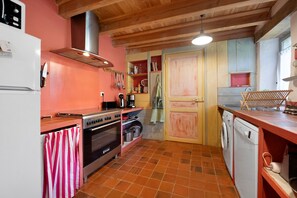 Una cocina compacta con estufa, horno y lavadora.