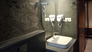 A bathroom with a rectangular sink, a mirror, and a towel rack.