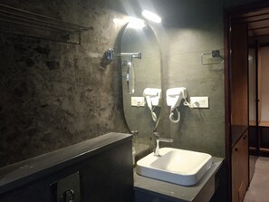 A bathroom with a rectangular sink, a mirror, and a towel rack.