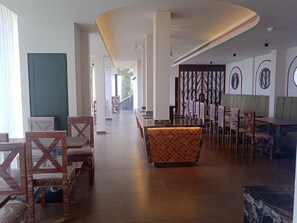 A hotel lobby with a reception desk, seating area, and a view of the outdoors. - Soul by Araiya, Paithalmala, A Vihaara Resort & Spa (Kannur)
