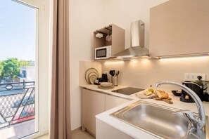 Una cucina moderna con lavello in acciaio inossidabile, forno a microonde e cappa aspirante.
