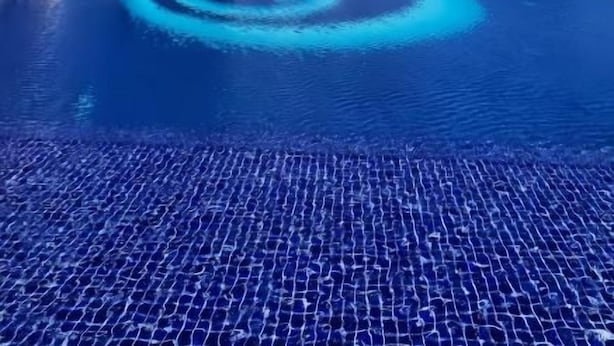 A high-rise building with a swimming pool in front. - Artisan Ratchada Condo Bangkok (Krung Thep Maha Nakhon)
