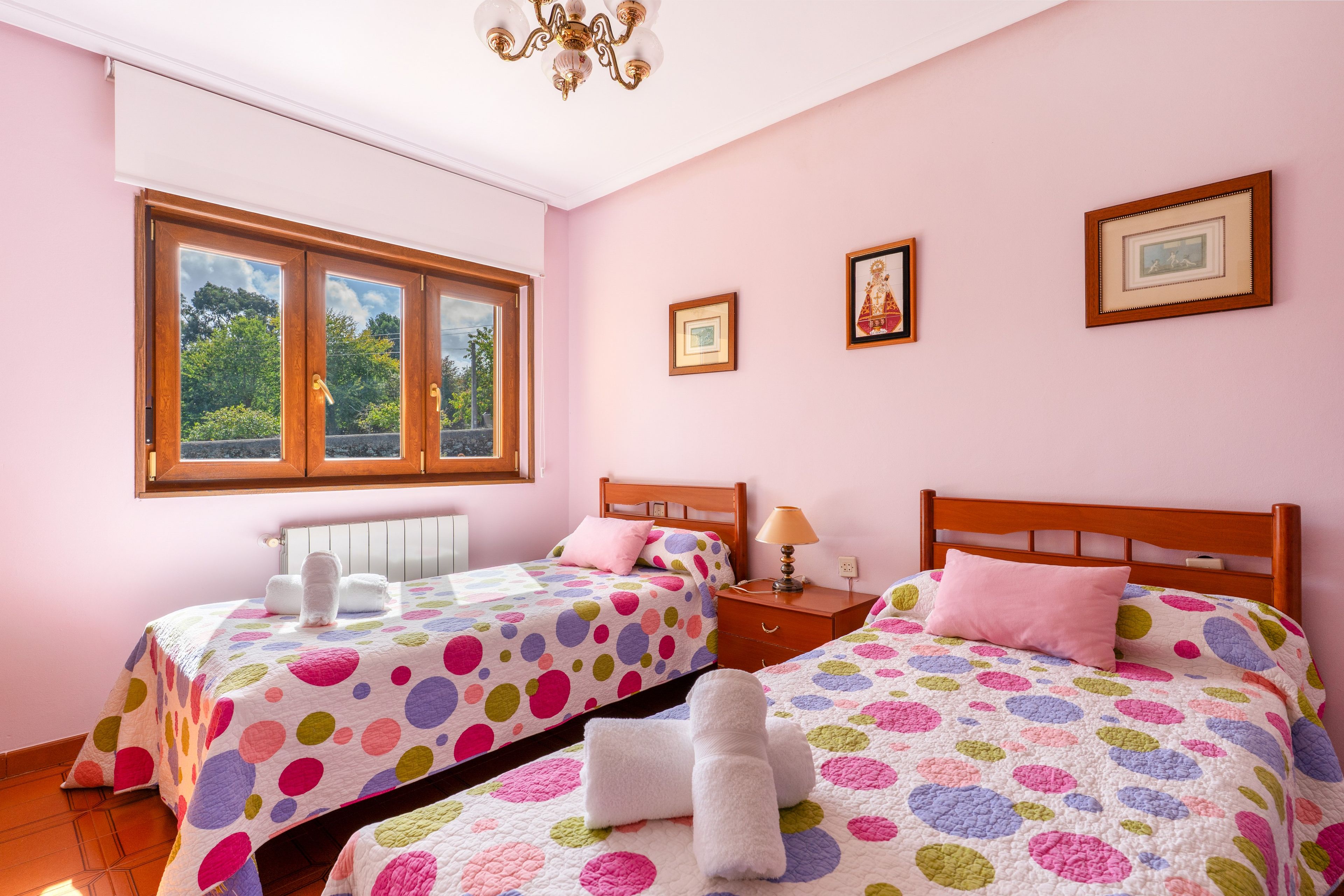 Un dormitorio con dos camas, una ventana y un radiador.