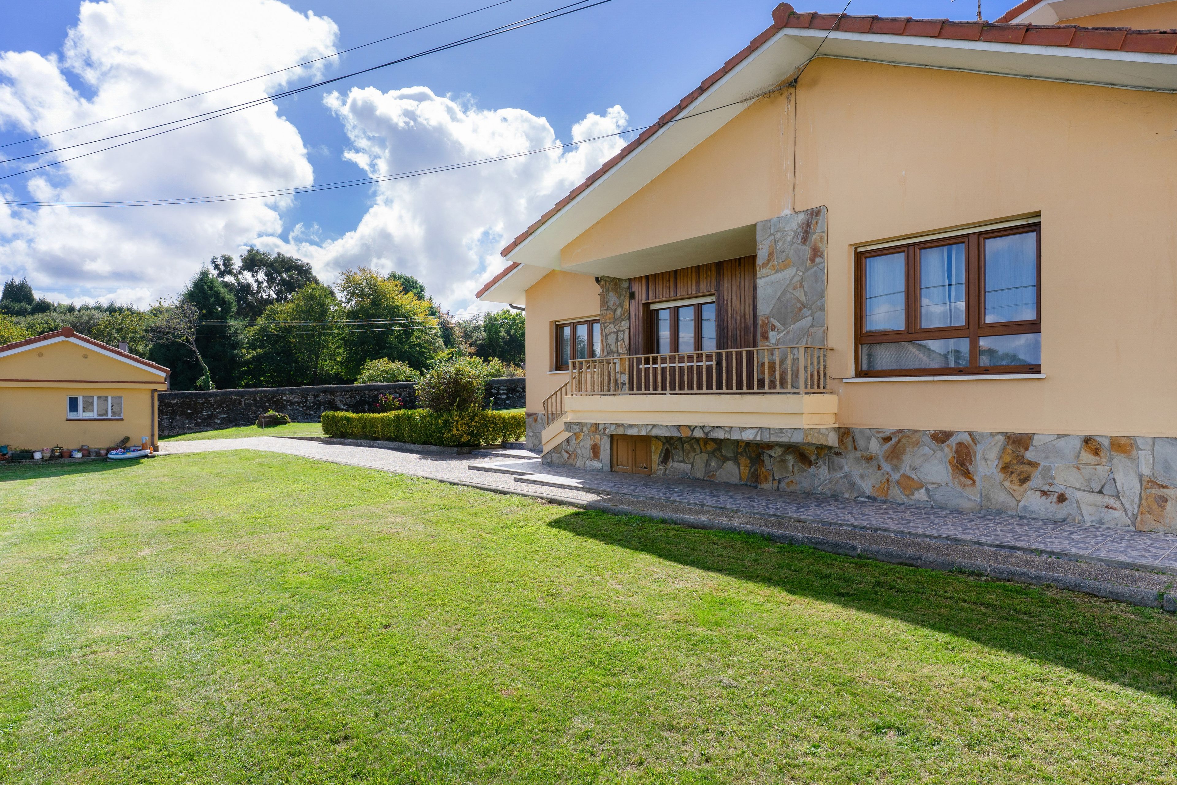Una casa de dos pisos con fachada de piedra y balcón.