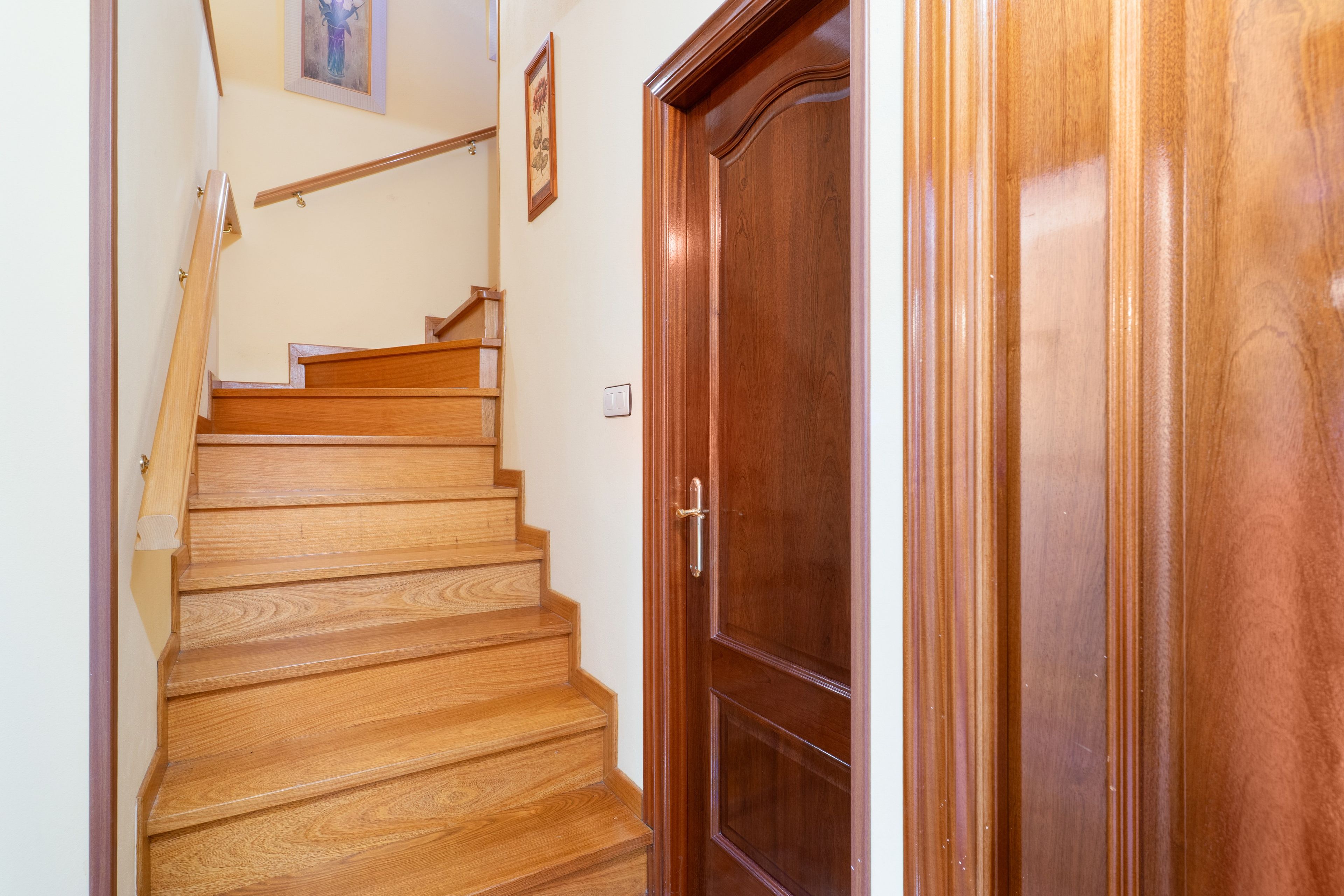 Una escalera de madera que lleva a una puerta con manija.