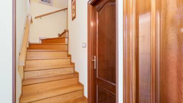 Una escalera de madera que lleva a una puerta con manija.