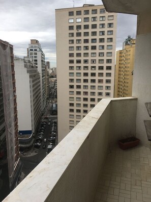 A high-rise building with multiple floors and windows, a parking lot below, and a view of the street. - Grande Apartamento no centro de Curitiba (Curitiba)