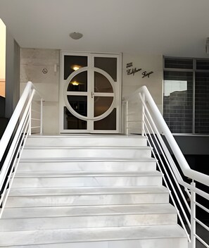 A staircase with white railings leading to a door with a circular window. - Grande Apartamento no centro de Curitiba (Curitiba)