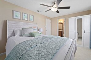 A bedroom with a bed, a ceiling fan, a wardrobe, and a door leading to a bathroom. - New Discount! Mayo Retreat, Pool, Close to Beach (Jacksonville)