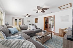 A living room with a grey sofa, a wooden coffee table, and a ceiling fan. - New Discount! Mayo Retreat, Pool, Close to Beach (Jacksonville)