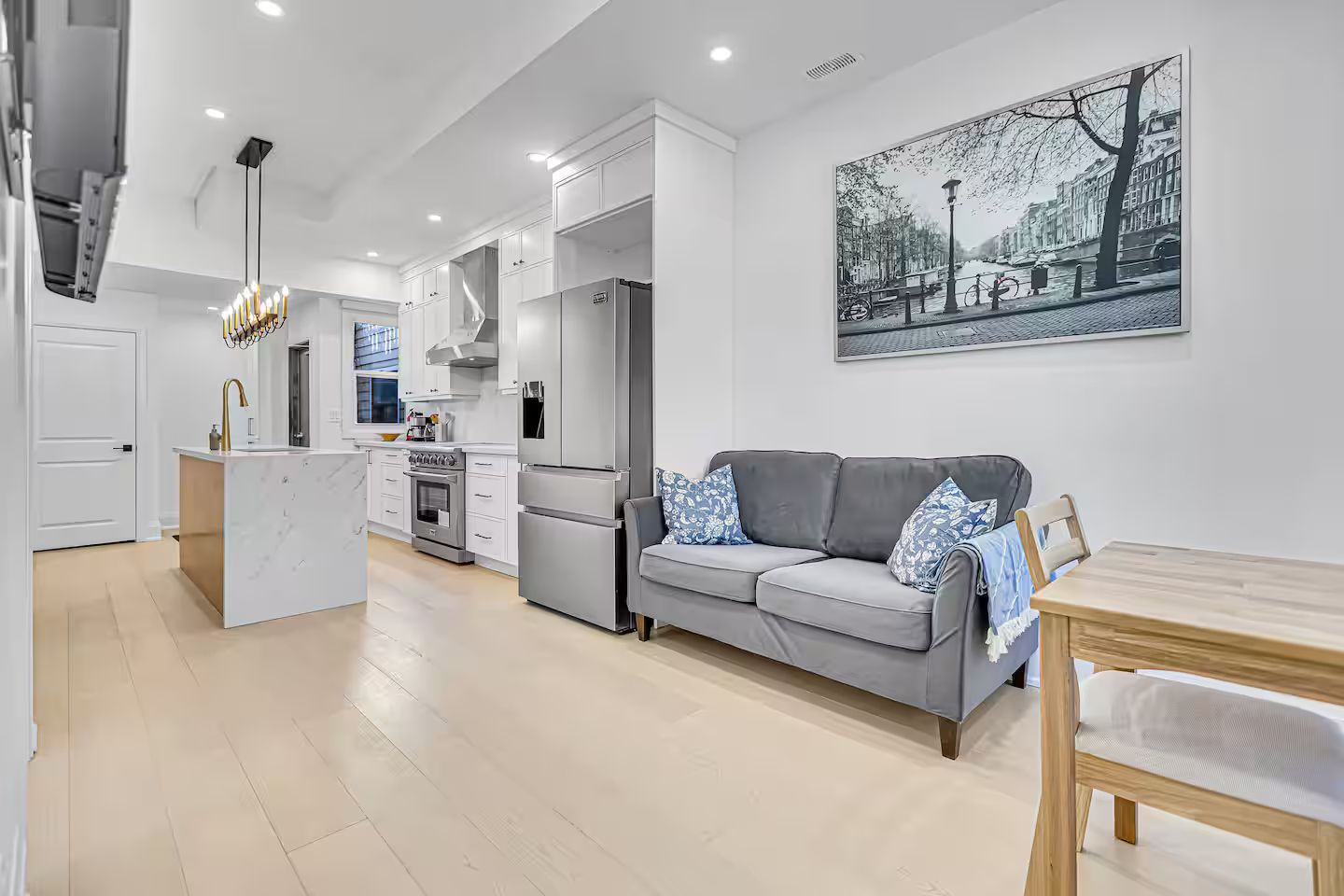 A modern kitchen with white cabinetry, a built-in oven, and a refrigerator.