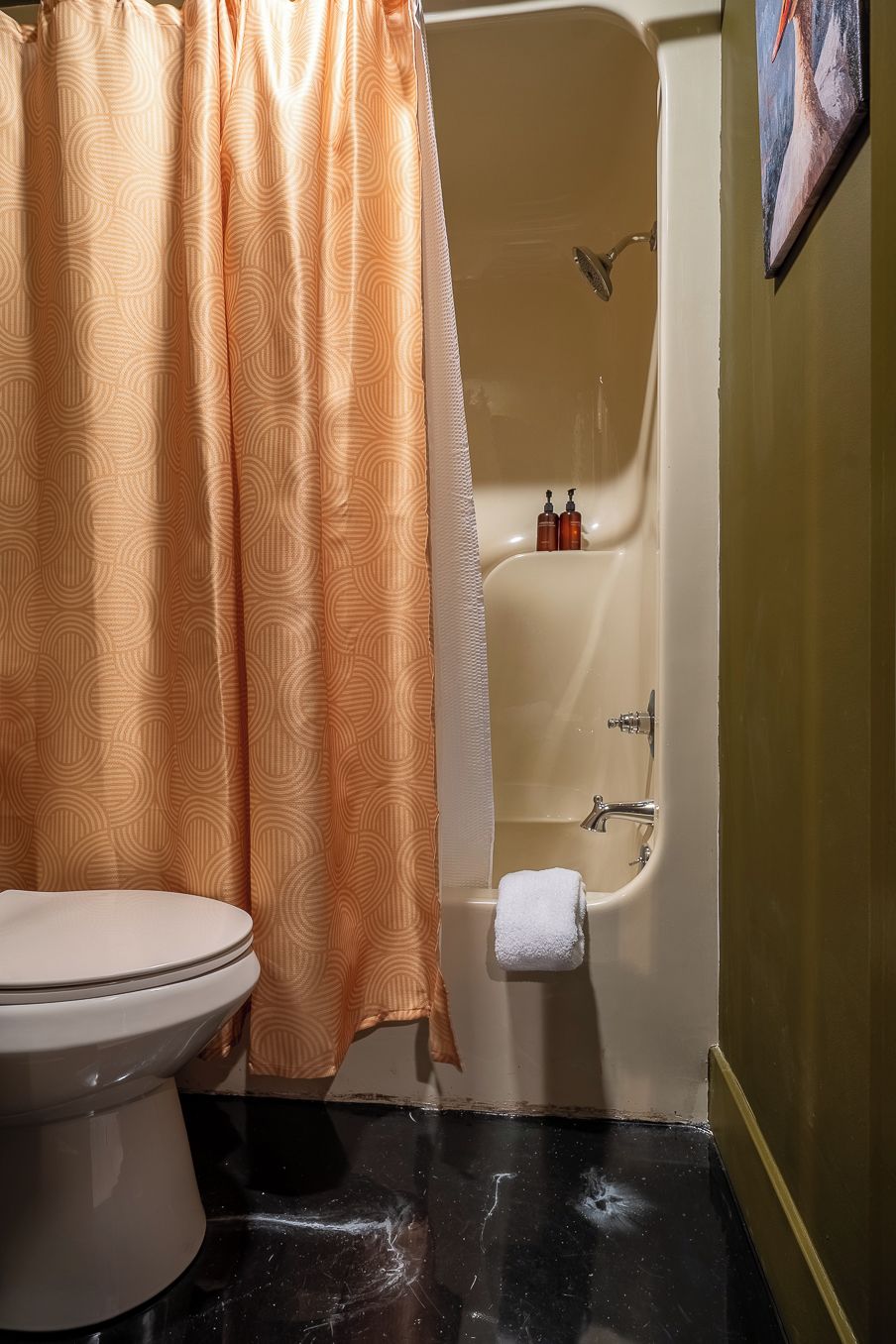 A bathroom with a toilet, a bathtub, and a shower curtain.