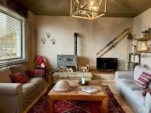 A cozy living room with a fireplace, sofas, a television, and decorative items.