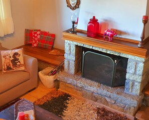 A cozy living room with a fireplace, a sofa, a coffee table, and a rug. - Eleni's Guesthouse Country House with Wi-Fi and Mountain Views (Επτάλοφος)