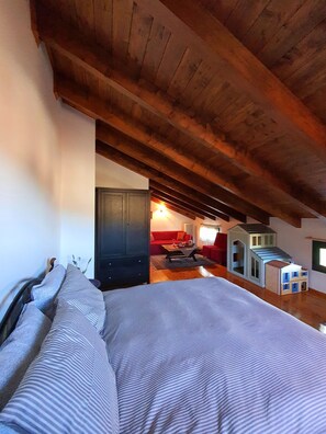 A bedroom with a bed, a wardrobe, and a small red sofa. - Eleni's Guesthouse Country House with Wi-Fi and Mountain Views (Επτάλοφος)