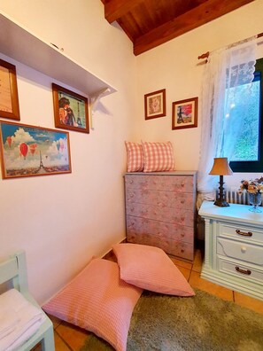 A bedroom with a bed, a dresser, a window with curtains, and wall-mounted artwork. - Eleni's Guesthouse Country House with Wi-Fi and Mountain Views (Επτάλοφος)