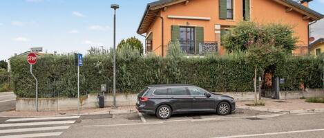 A residential street with a stop sign, a pedestrian crossing, and a parked car.