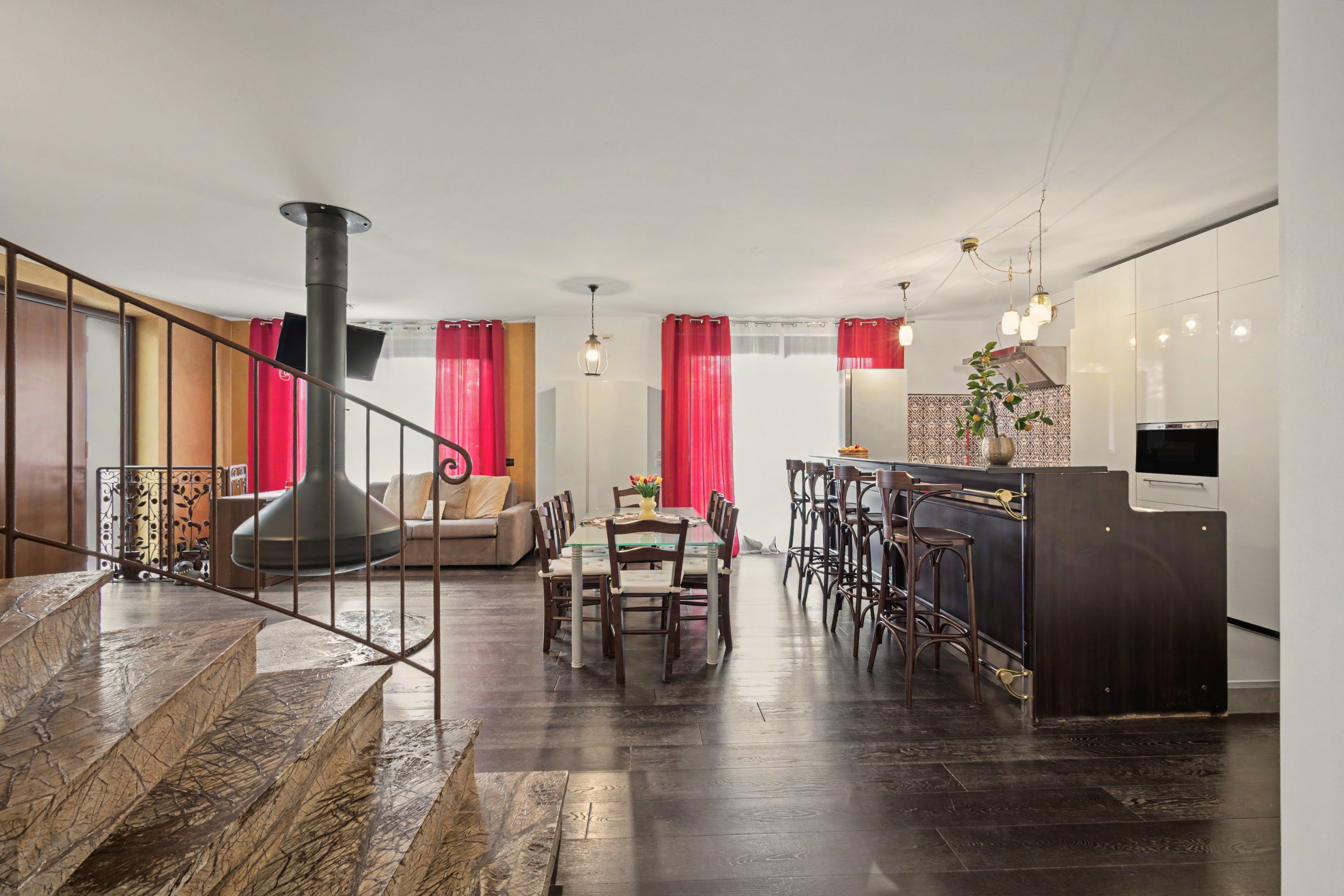 Un interior moderno con una escalera, un comedor y una cocina.