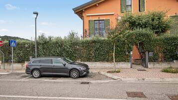 Ein geparktes Auto vor einem Gebäude, in der Nähe ein Fußgängerüberweg.
