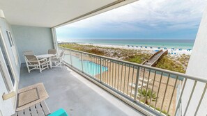 A balcony with a pool, beach view, and lounge chairs. - Spacious Beautiful Islander Beach 3009 (Fort Walton Beach)