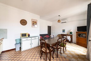 A compact living space with a dining area, kitchenette, and a television. - L'Azur Édouard VII - à 300 m des plages (Menton)